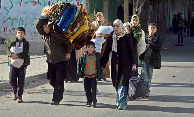 Palesztin család tagjai átmeneti szállást keresnek, miután az izraeli hadműveletek miatt maguk mögött hagyták a Gázai  övezet keleti részében lévő házukat 