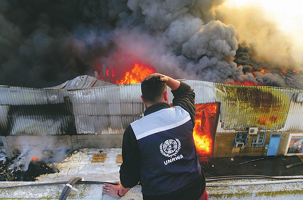 ENSZ-segélymunkás a szervezet égő épülete előtt