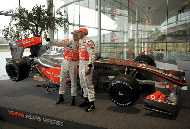 McLaren Formula One motor racing team driver Heikki Kovalainen of Finland (L) takes a photograph of himself and team-mate Lewis Hamilton of Britain during the unveiling of McLaren's MP4-24 F1 car at the company's headquarters in Woking, southern Engl