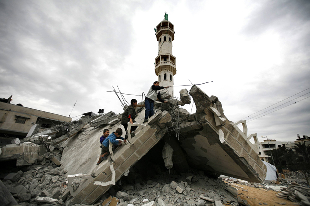 Palestinian boys climb the ruins of a destroyed mosque in Jabalya in the northern Gaza Strip January 20, 2009. Israel planned to complete a troop pullout from Gaza before Barack Obama's inauguration on Tuesday, Israeli political sources said, in what
