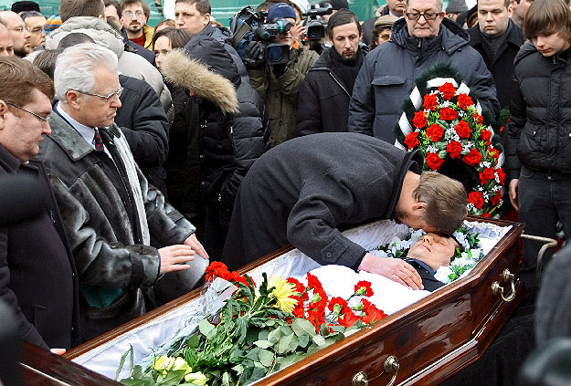 Családtagjai és gyászolók búcsúznak a koporsóban fekvő Sztanyiszlav Markelov orosz ügyvédtől a 2009. január 23-i temetési szertartáson Moszkvában. Markelovot, aki ellenezte a csecsen Elza Kungajeva meggyilkolásával vádolt orosz ezredes, Jurij Budanov