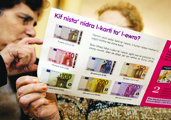 Máltai nyugdíjasok tanulmányozzák az új bankjegyeket bemutató prospektust