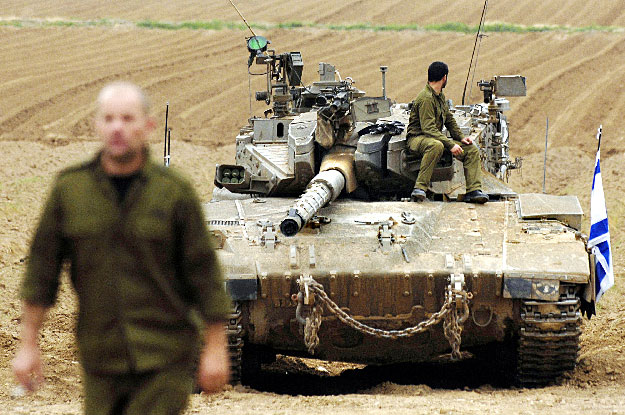 An Israeli soldier sits atop a tank (R) at a military staging area outside the northern Gaza Strip January 23, 2009. Israel's invasion of Gaza has strengthened the hand of extremists and only a credible independent investigation into alleged wrongdoi
