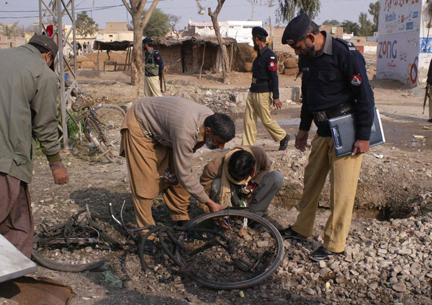 Pakisztáni biztonsági emberek vizsgálják a merénylet színhelyét