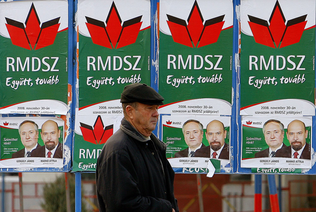 A Romániai Magyar Demokrata Szövetség (RMDSZ) választási plakátja mellett megy el egy férfi a Brassó megyei Fogarasban 2008. november 27-én. Romániában 2008. november 30-án tartanak parlamenti választásokat