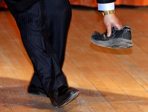 Wen Jiabao egyik testőre 'hatástalanítja' a Tibet-párti tüntető által dobott cipőt a cambridge-i egyetem előadójában. Kínai gyártmány?