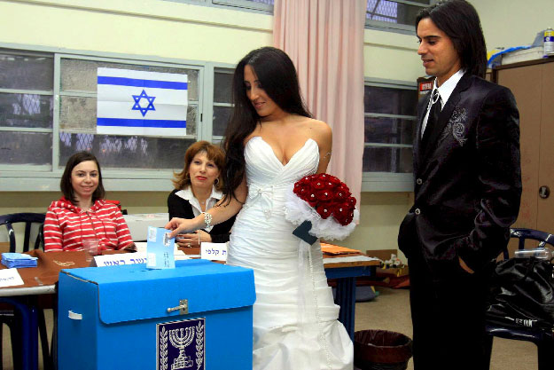 Menyasszony s vőlegény esküvőre menet adja le szavazatát az izraeli parlamenti választások napján a dél-izraeli Askelónban 2009. február 10-én.