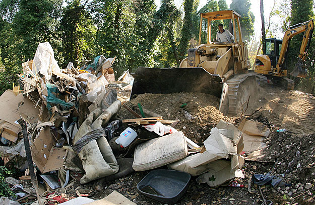 Munkások munkagépekkel tisztítják meg egy kiürített illegális roma tábor helyét a Tor di Quinto vaútállomás mellet, Olaszországban