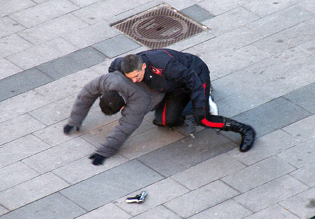 Az 2009. február 11-én közzétett képen egy menekülő bankrabló elejti pisztolyát, amikor üldözője, egy olasz csendőr derékon kapja őt Torinóban 2009. február 10-én, miután három férfi - kettő közülük Silvio Berlusconi olasz miniszterelnök és Marcello 