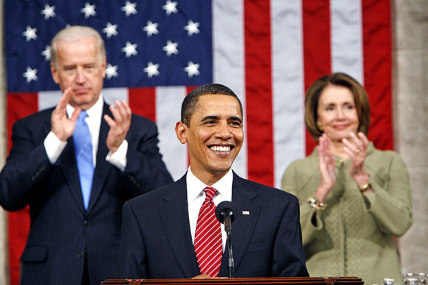 Barack Obama a háttérben tapsoló Joe Biden alelnökkel és Nancy Pelosi képviselőházi elnökkel