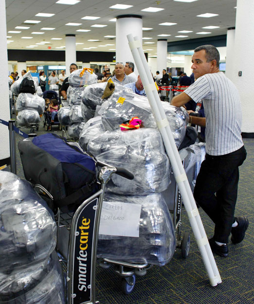 A Cuban-American travelling to Cuba waits in line to check in his luggage at the Miami international Airport, Florida, February 27, 2009.  U.S. restrictions on trade with Cuba and family travel to the island would be eased under legislation passed by