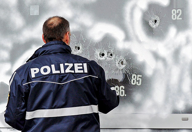 Golyóütötte lyukakat jelöl be egy rendőr a németországi Winnenden Albertville Reáliskolában történt véres ámokfutás után