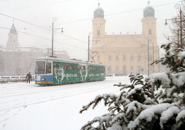 A villamos halad Debrecen behavazott belvárosában. A város, március vége felé ritkán látott télies idõjárásra ébredt. A mínusz 3 Celsius-fokos hideg mellett rövid idõ alatt 6 centiméteres hó esett a városra, erõs szél kíséretében.