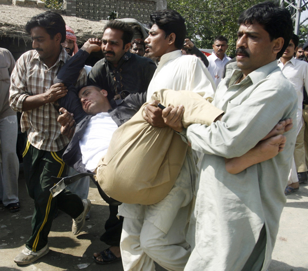 Egy sebesültet szállítanak a kelet-pakisztáni rendőrakadémia elleni színhelyen, 2009. március 30-án 
