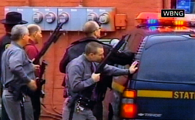 A New York állambeli Binghamton város WBNG-TV televíziós csatornája által közzétett képen a rendőrök fedezékbe húzódnak, miután egy férfi több tucat túszt ejtett egy bevándorlókat segítő szervezet épületében 2009. április 3-án