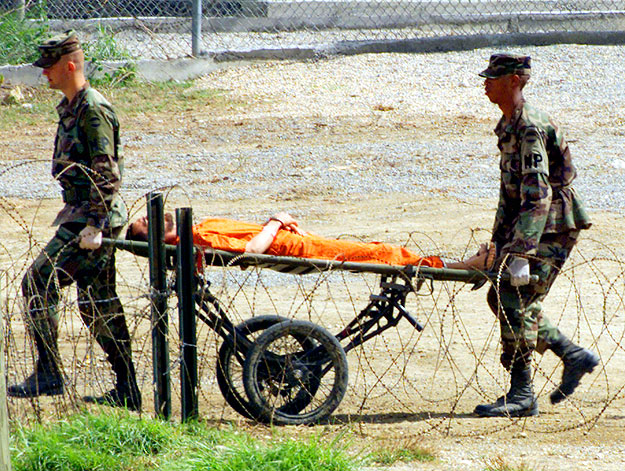 Guántanamón szállítanak egy foglyot a katonai rendészek 2002. februárjában 
