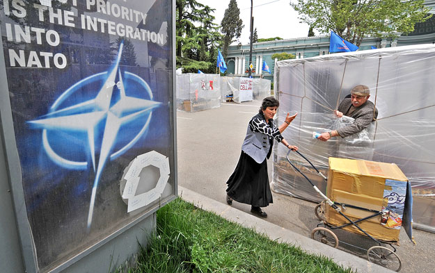 A NATO-tagságot népszerűsítő plakát Tbilisziben - jégkrémárus a grúz fővárosban