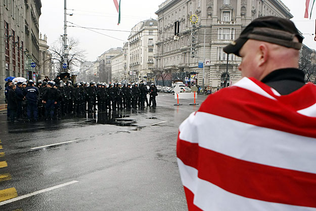 Rendőrökkel farkasszemet néző tüntető