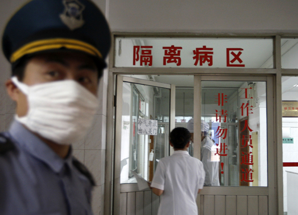 Rendőr posztol a kantoni (Guangzhou) kórházi azon osztálya előtt, ahol az új vírusban megbetegedett pácienst tartanak elkülönítve 2009. május 18-án 