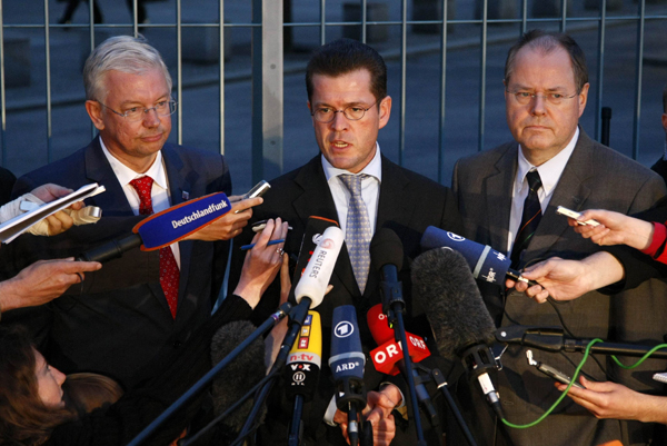 Roland Koch, Hesse tartományi kormányzója, valamint Karl-Theodor zu Guttenberg gazdasági- és Peer Steinbrueck pénzügyminiszter az Opel válságcsúcsa utáni tájékoztatón