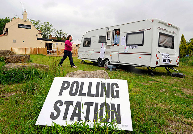 A woman prepares to vote at a polling station in the remote village of Biggin, northern England, June 4, 2009. British Prime Minister Gordon Brown faced a new test of his leadership in European and local elections on Thursday, with rebels in his ruli