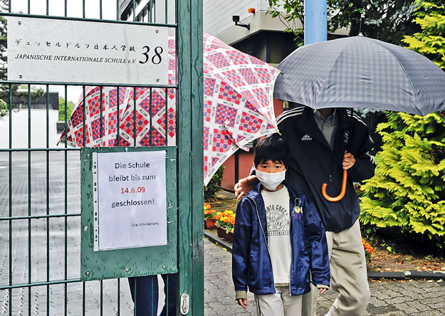 A Japanese school boy wears as face mask as he leaves the Japanese International School in a suburb of the western German city of Duesseldorf June 11, 2009. German authorities have confirmed 30 cases of the H1N1 flu at the school in Duesseldorf, the 