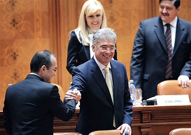 Emil Boc román kormányfő kézfogása Adriean Videanu gazdasági miniszterrel. A háttérben Elena Udrea