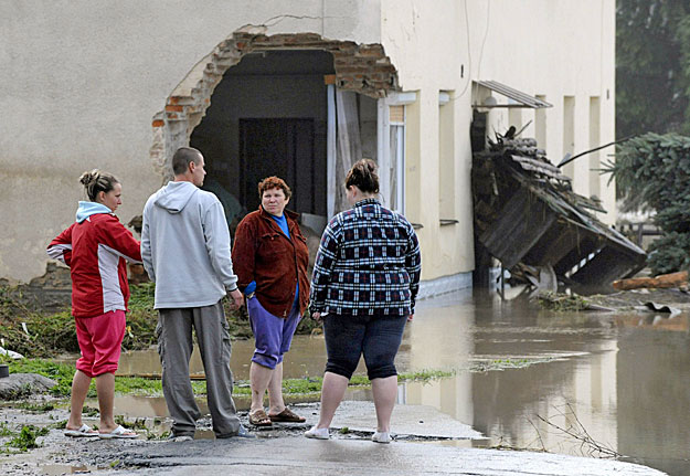 Csehországban a heves esőzések nyomán folyók léptek ki medrükből. Megrongálódott ház előtt helyi lakosok az áradás okozta pusztításokat nézik Jesenik nad Odrouban
