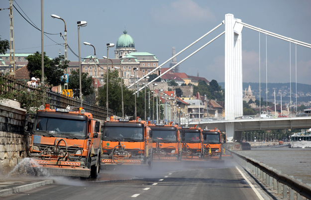 Fővárosi Közterület-fenntartó Zrt. autói tisztítják a budai alsó rakpartot a Duna hordalékaitól a korábban elöntött útszakaszon