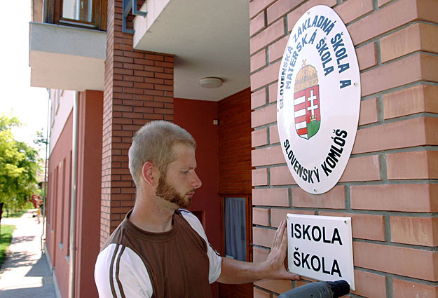 Szlovák és magyar nyelvű táblát szerelnek egy tótkomlósi iskola falára. A településen az intézmények és utcák neveit is mindkét nyelven kiírták