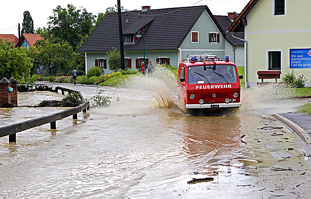 Tűzoltóautó gázol az utcát elárasztó vízben a Graz melletti Raaba településen 2009. július 18-án, miután özönvízszerű eső zúdult a térségre