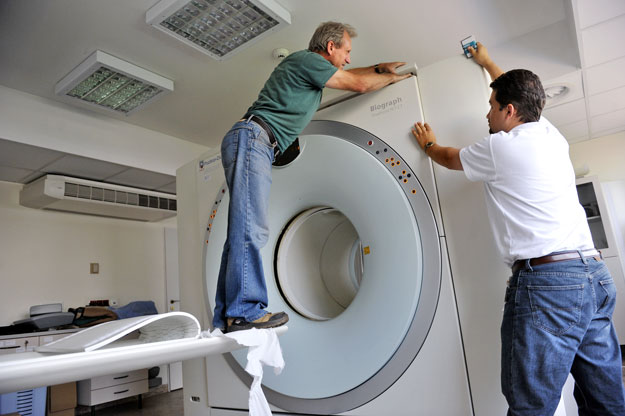 A Siemens szakembere (jobbra) CT-gépet szerel egy budai diagnosztikai központban