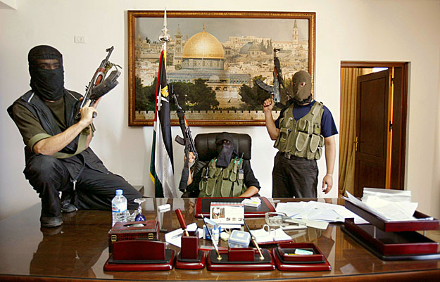 Hamas fighters pose in Palestinian President Mahmoud Abbas' personal office after they captured it in Gaza June 15, 2007. Abbas dismissed the Hamas-led Palestinian government and declared a state of emergency as the Islamist group's gunmen routed his