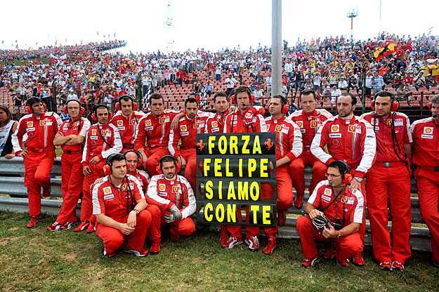 Hajrá Felipe, veled vagyunk - olvasható a pilóták számára a verseny alatt információkat közvetítő táblán, amelyet a Ferrari-csapat Massa mellett dolgozó munkatársai tartanak a magyar nagydíj rajtja előtt