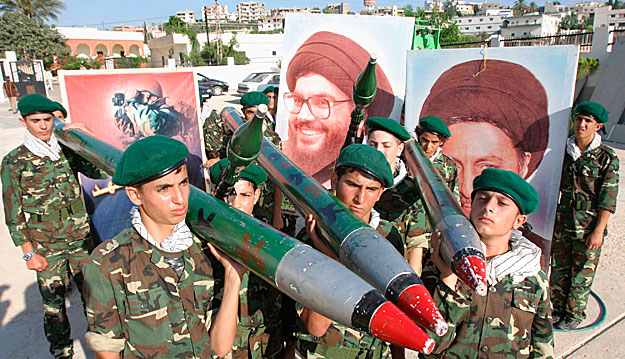 Hezbollah-aktivisták felvonulása rakétamasékkal és Haszan Naszrallah sejk arcképével