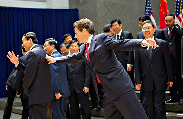 Timothy Geithner amerikai pénzügyminiszter nyújtózik, hogy elérje Vang Csi-san (Wang Qishan) kínai miniszterelnök-helyettest
