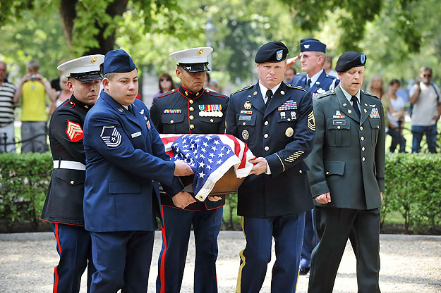 Amerikai katonák viszik a zászlóval letakart koporsót