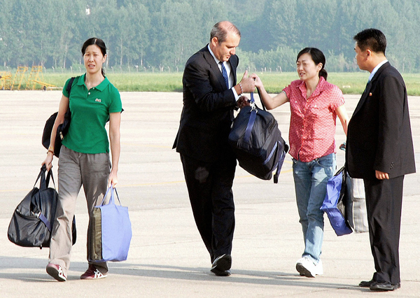 Laura Ling és Euna Lee a phenjani repülőtér kifutópályáján a gép felé tart 2009. augusztus 5-én