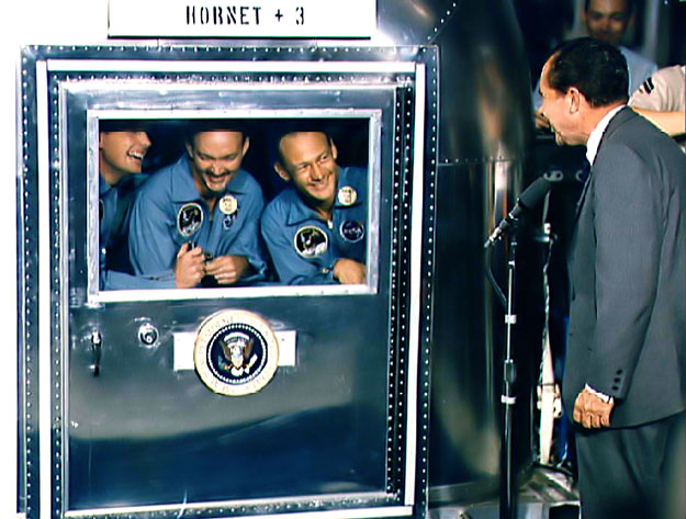 Nixon gratulál az Apollo 11 legénységének a USS Hornet repülőgép-hordozón. Az űrhajósok 3 hétig nem hagyhatták el az izolációs kamrát