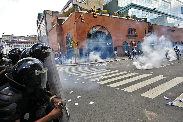 Tüntetők menekülnek a könnygáz elől Caracasban
