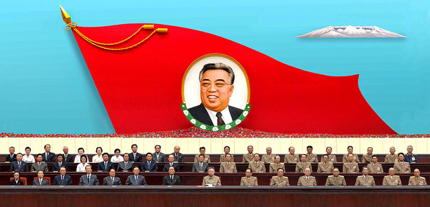 Kim Dzsong Il (elöl középen) apja portréja alatt