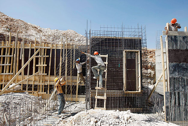 Palesztin munkások dolgoznak egy Jeruzsálem közeli telep megépítésén