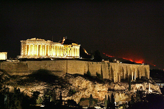 Az Akropoliszon álló Parthenon mögött a tűvész lángjai láthatóak 2009. augusztus 24-én
