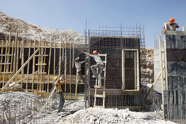 Palesztin munkások dolgoznak egy Jeruzsálem közeli telep bővítésén