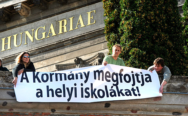 A kormány oktatáspolitikája ellen tüntetők feliratokat helyeznek el Esztergomban a bazilika előtt\n