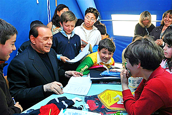 Silvio Berlusconi iskolásokkal játszik az áprilisi földrengés által romba döntött közép-olaszországi Poggio Picenze-ben 
