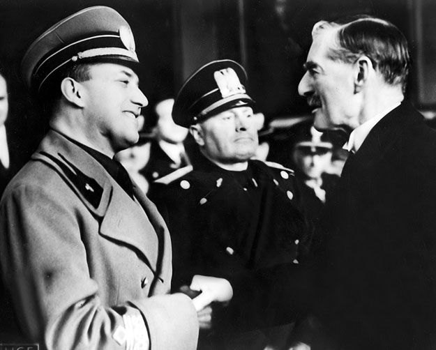 Az 1939. január 14-én készült felvételen Benito Mussolini jelenlétében Galeazzo Ciano olasz külügyminiszter kezet fog Sir Neville Chamberlain brit miniszterelnökkel a római Termini pályaudvaron