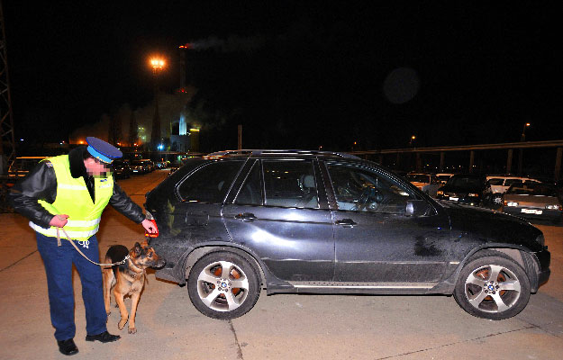Egy rendőr vizsgálja a a BRFK egyik XV. kerületi telepén azt az X5-ös BMW-t, mely az egyik, Ausztriában fogva tartott gyanúsított tulajdonában van. Az autót egy XIII. kerületi tömbház mélygarázsában találták meg
