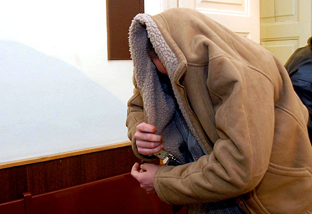 Kabátjával takarja el fejét a Pécsi Városi Bíróságon az a 19 éves férfi, akit azzal gyanúsítanak, hogy feszítővassal agyonverte egy hitelező cég pénzbeszedőjét
