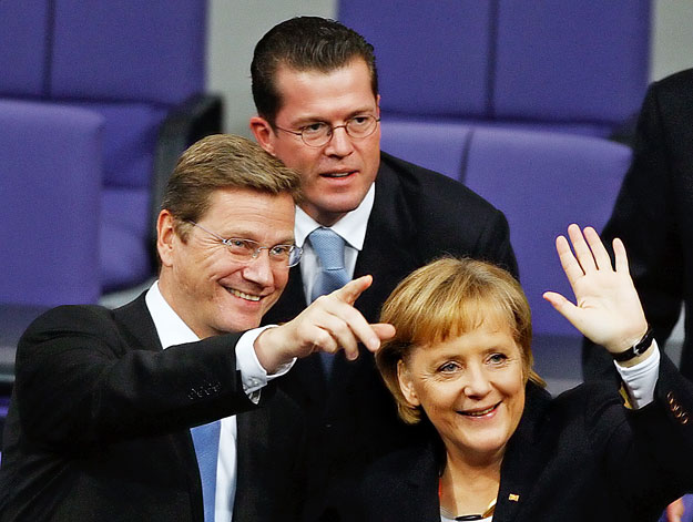 Guido Westerwelle külügyminiszter és az újraválasztott  kancellár mögött Karl-Theodor zu Guttenberg, a 2.0-s Merkel-kormány védelmi minisztere